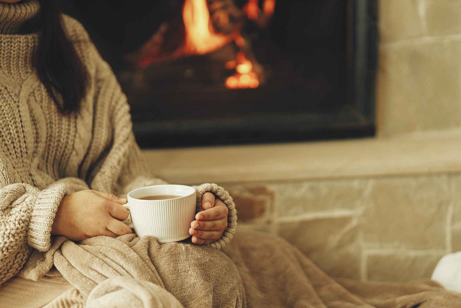 Girl with cup by the fireplace